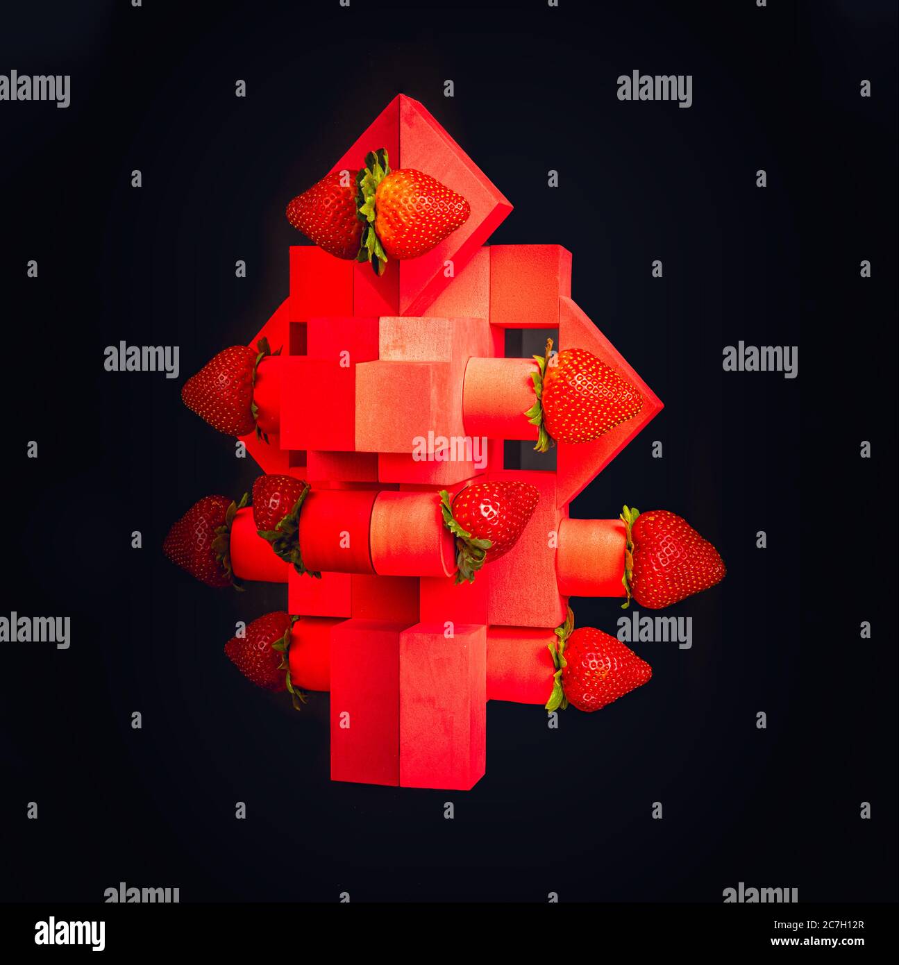 Strawberries on red geometrical structures on black background Stock Photo