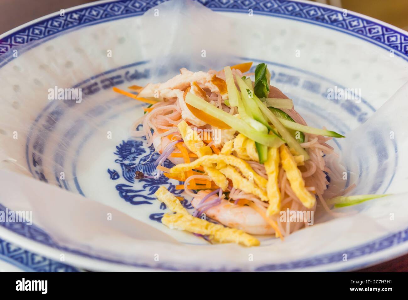Making a vietnamese spring roll with rice paper, noodles, prawns, egg
