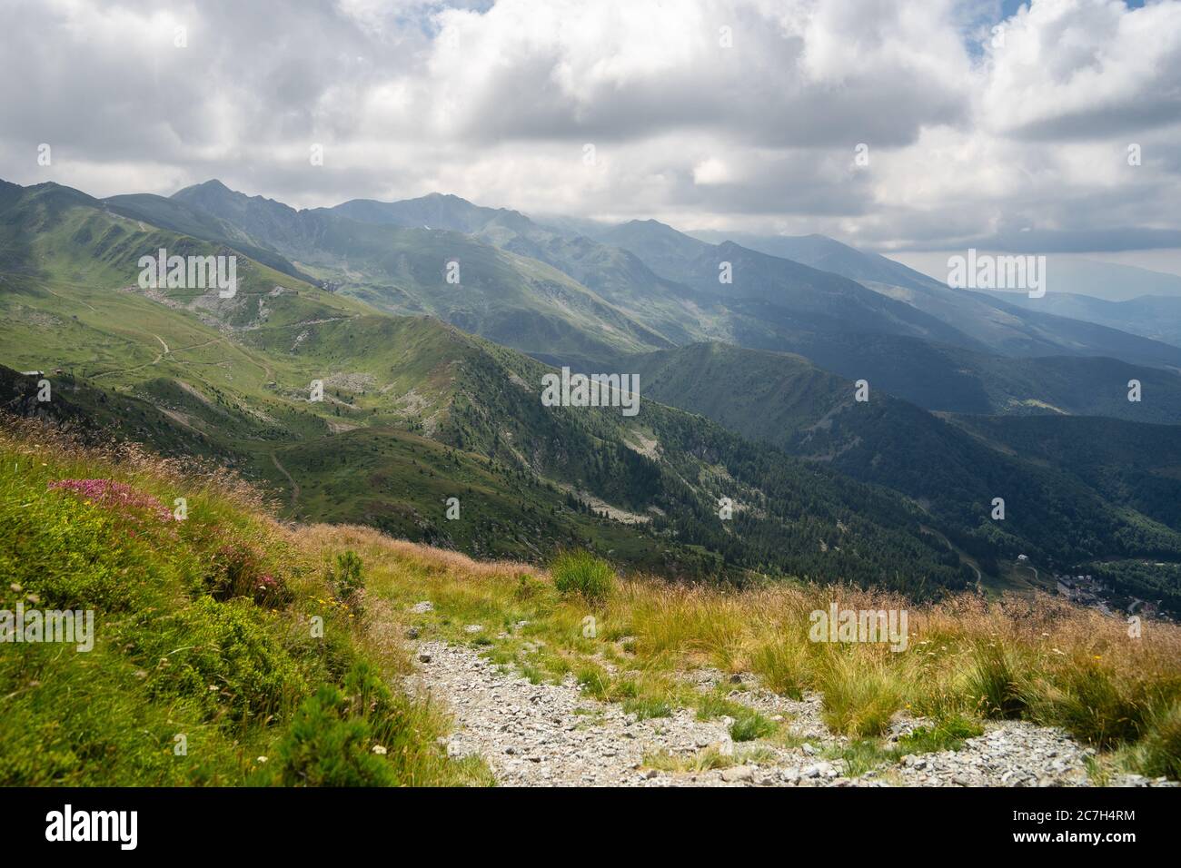 Landscape of hills covered in greenery with rocky mountains under a ...