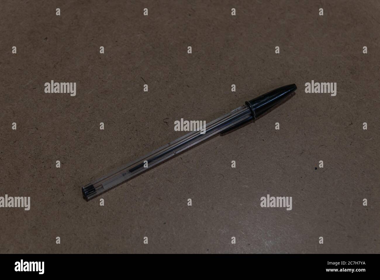 Closeup shot of a black pen on a brown surface Stock Photo
