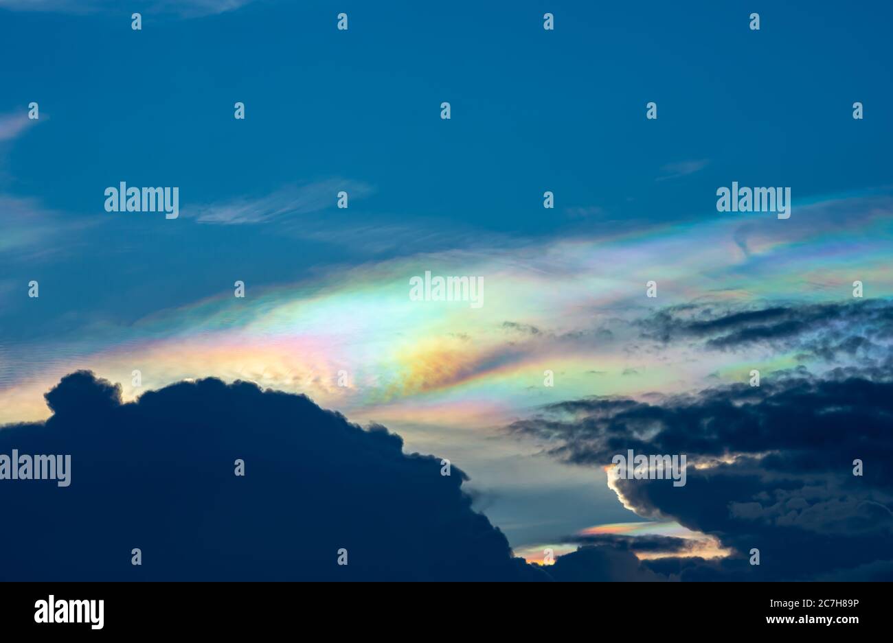 The beauty of the rainbow clouds Above the black clouds in the evening. Stock Photo