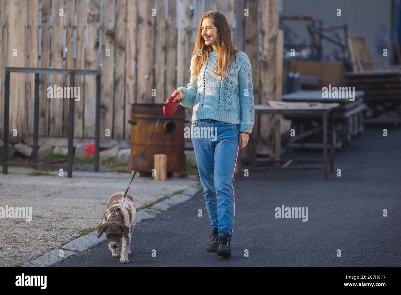 young woman walking her dog on the street Stock Photo - Alamy