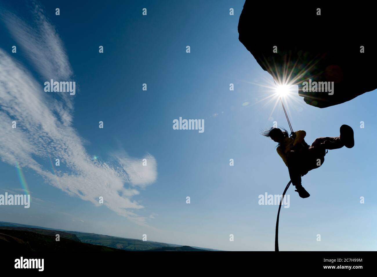 woman rappelling from cliff at Windgather rocks in the Peak District