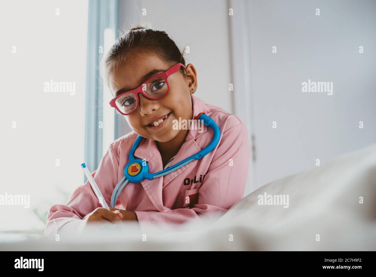 Multi racial girl dressed up as a doctor looking at camera Stock Photo
