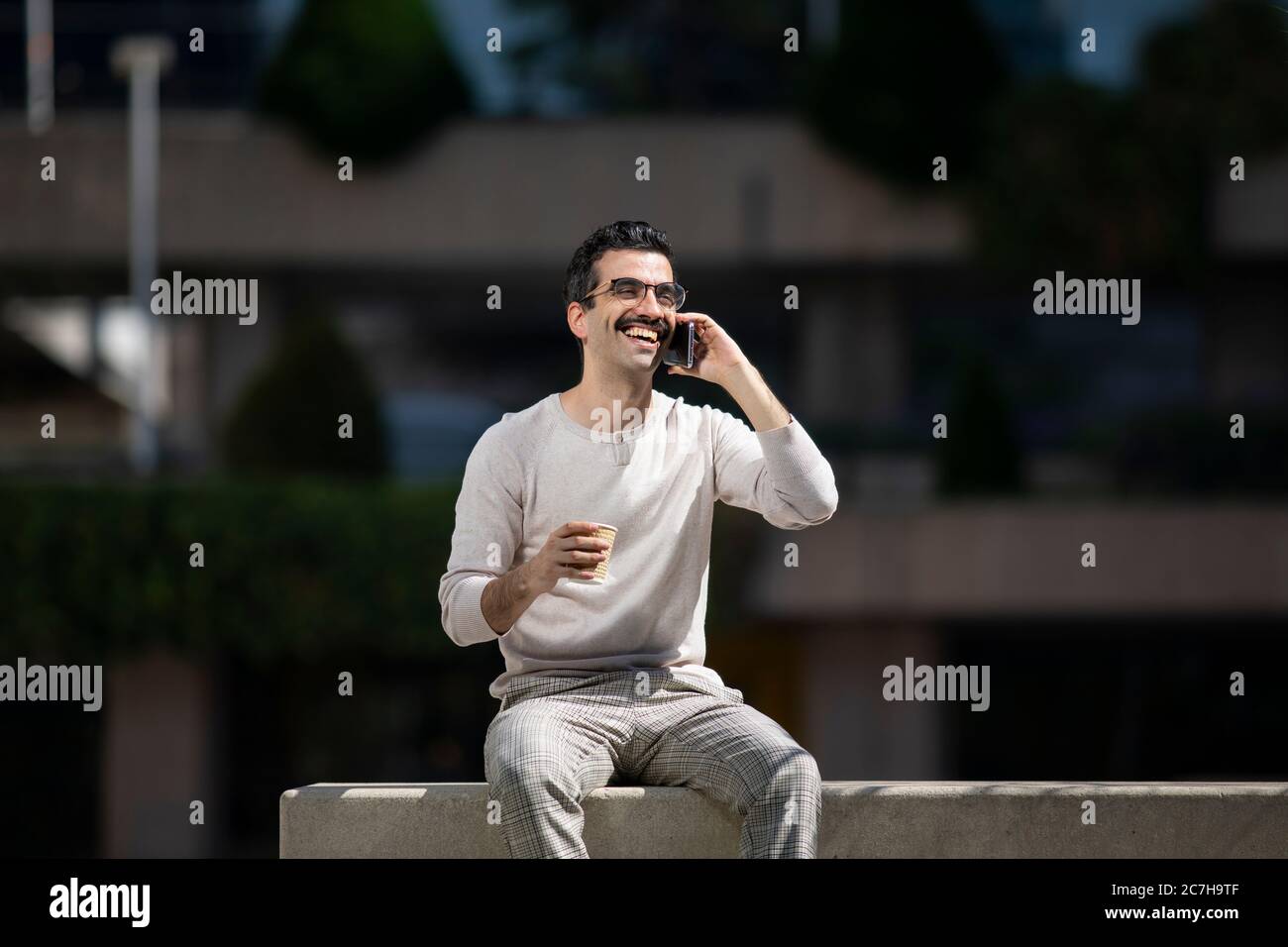 young smiling executive man next to offices talking on the phone Stock Photo