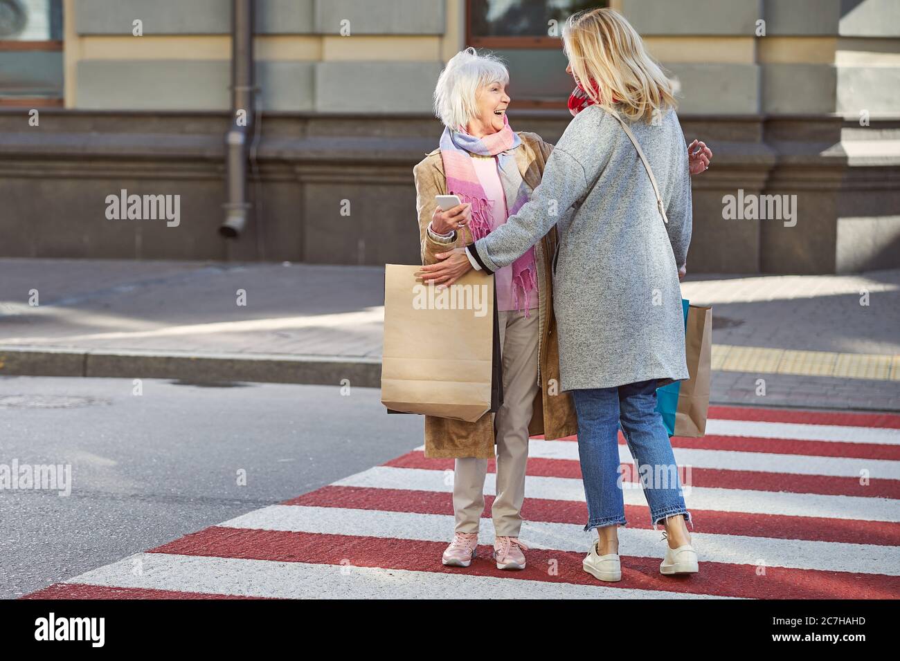 Happy meeting two women in the pedestrian crossing Stock Photo - Alamy