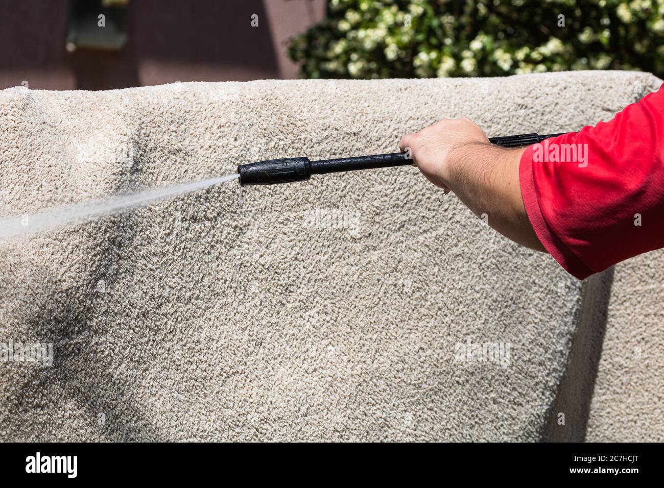 Close up of washing carpets with high pressure washer. Cleaning the carpet with a gun for