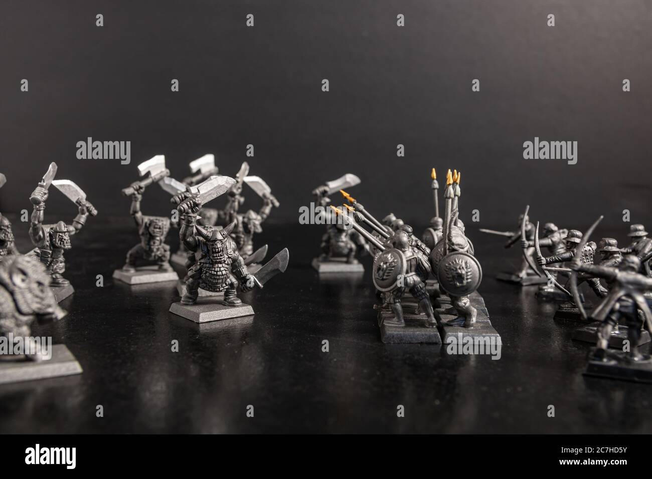 Grayscale selective focus shot of mythical creatures near soldiers with spear figurines Stock Photo