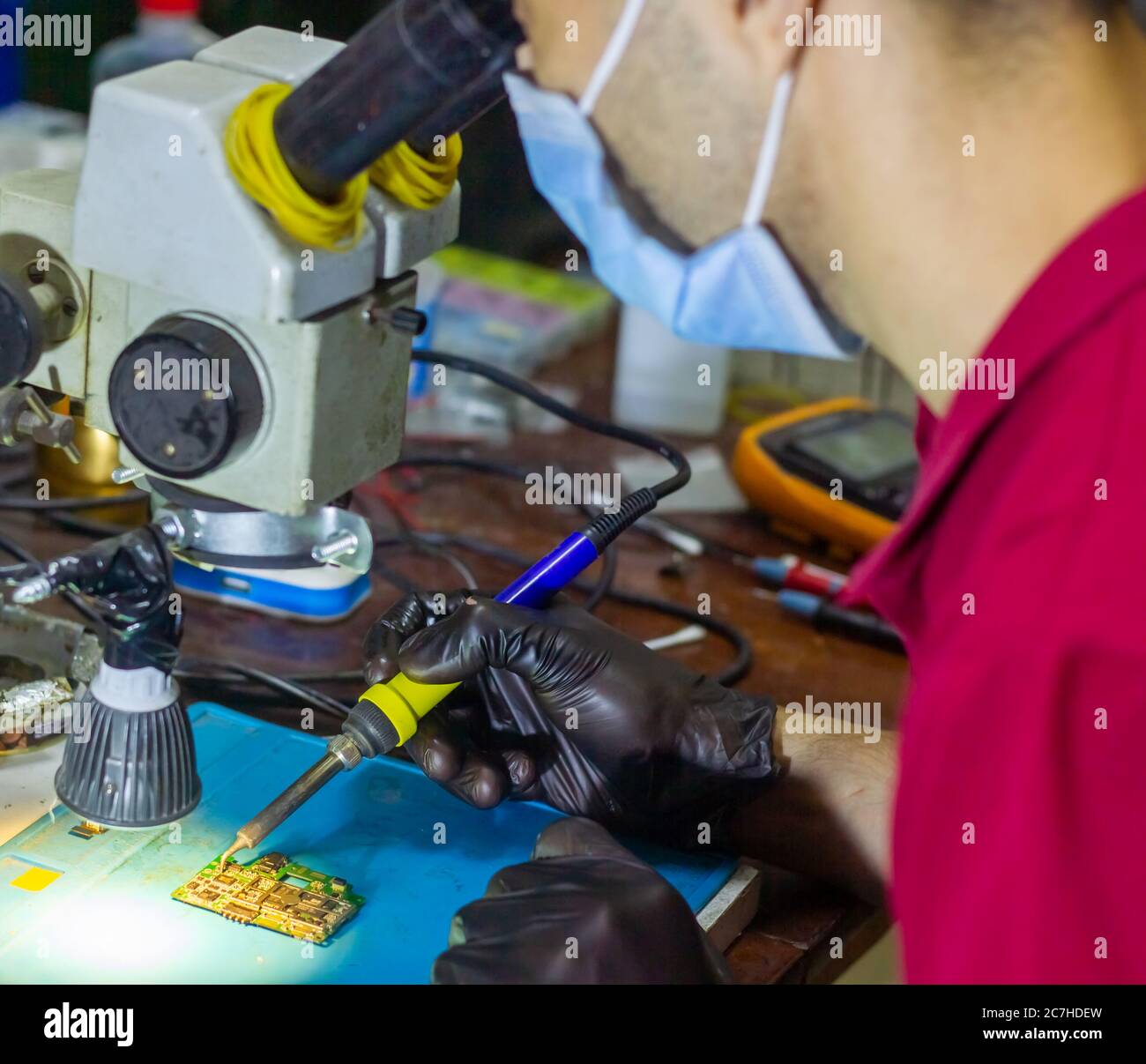 service worker repairing mobile phone with microscope Stock Photo Alamy