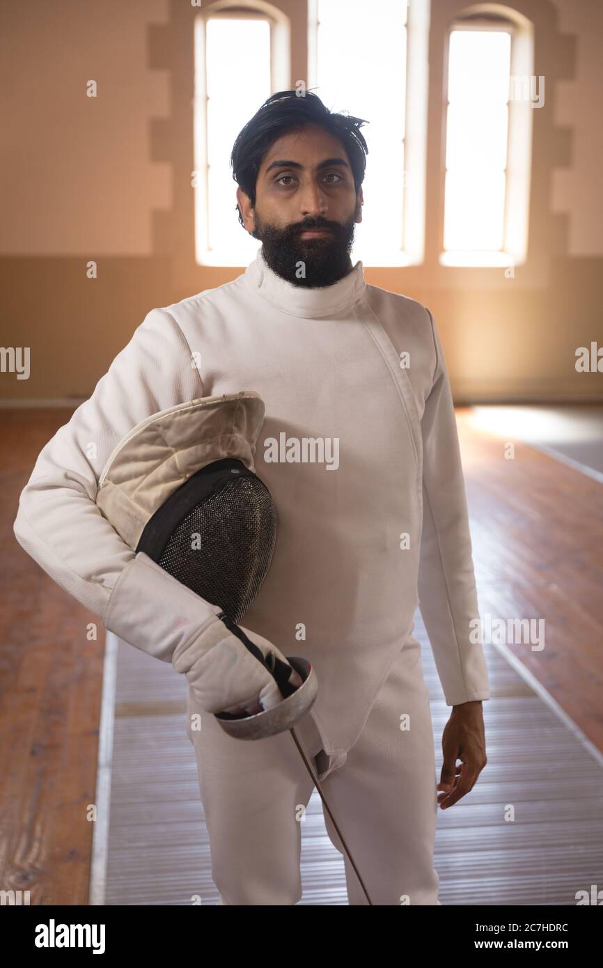 Portrait of man holding fencing foil and mask Stock Photo