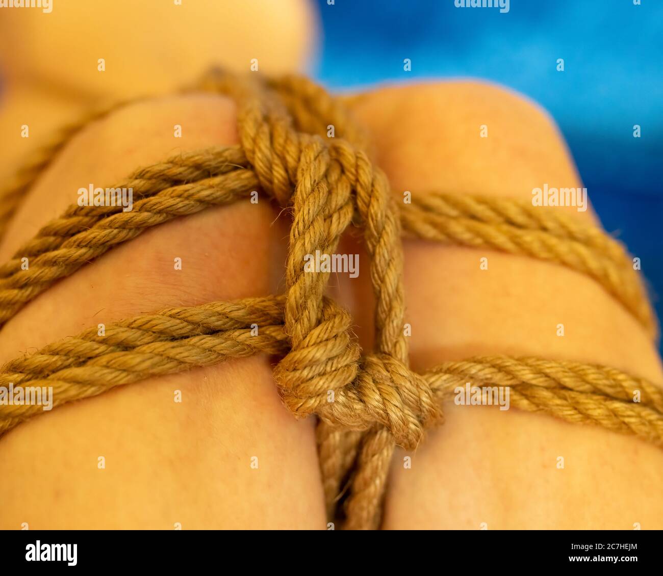 Selective focus on knot Anonymous young woman leg in mermaid futomomo tie with jute rope Stock Photo