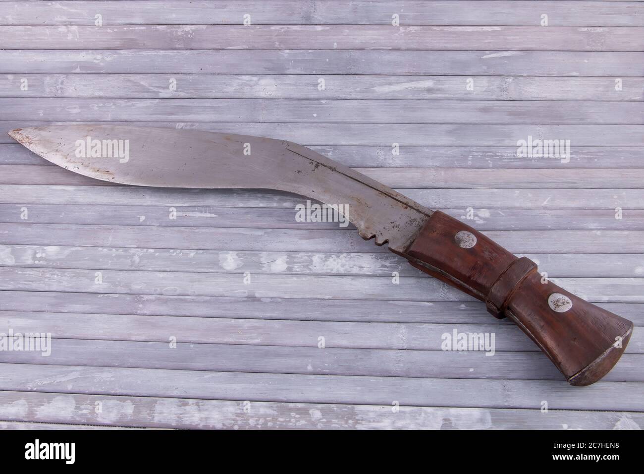 Vintage Ghurkha Khukri Knife, slightly rusty on curved metal blade. Isolated on gray background Stock Photo