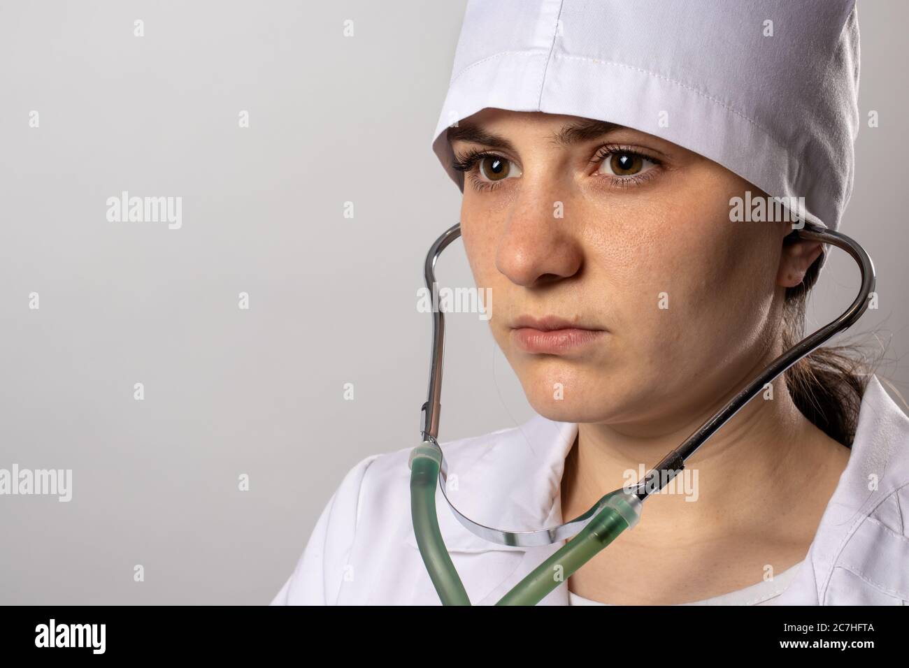 Female doctor in white uniform with a green stethoscope Stock Photo - Alamy