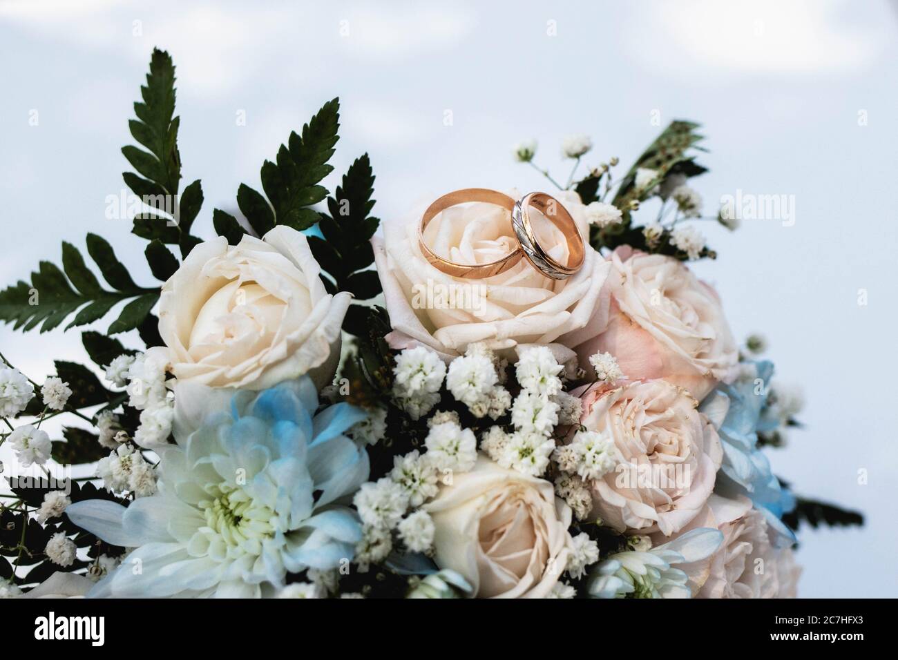 Gold rings on the bride's bouquet of roses on the wedding day Stock Photo