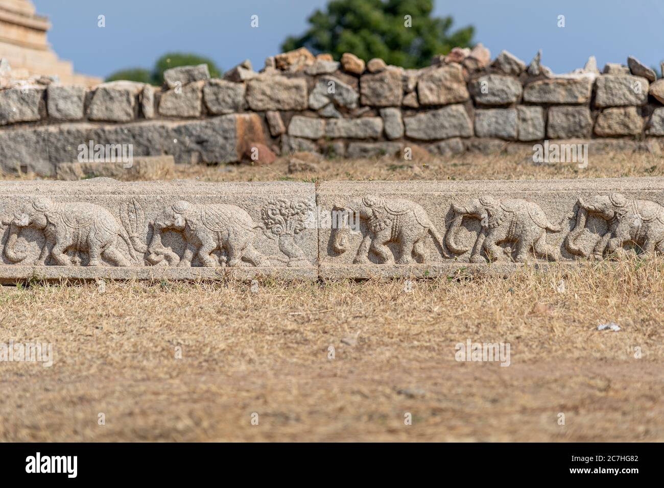 Stone edge with elephant relief and weathered wall in the background Stock Photo
