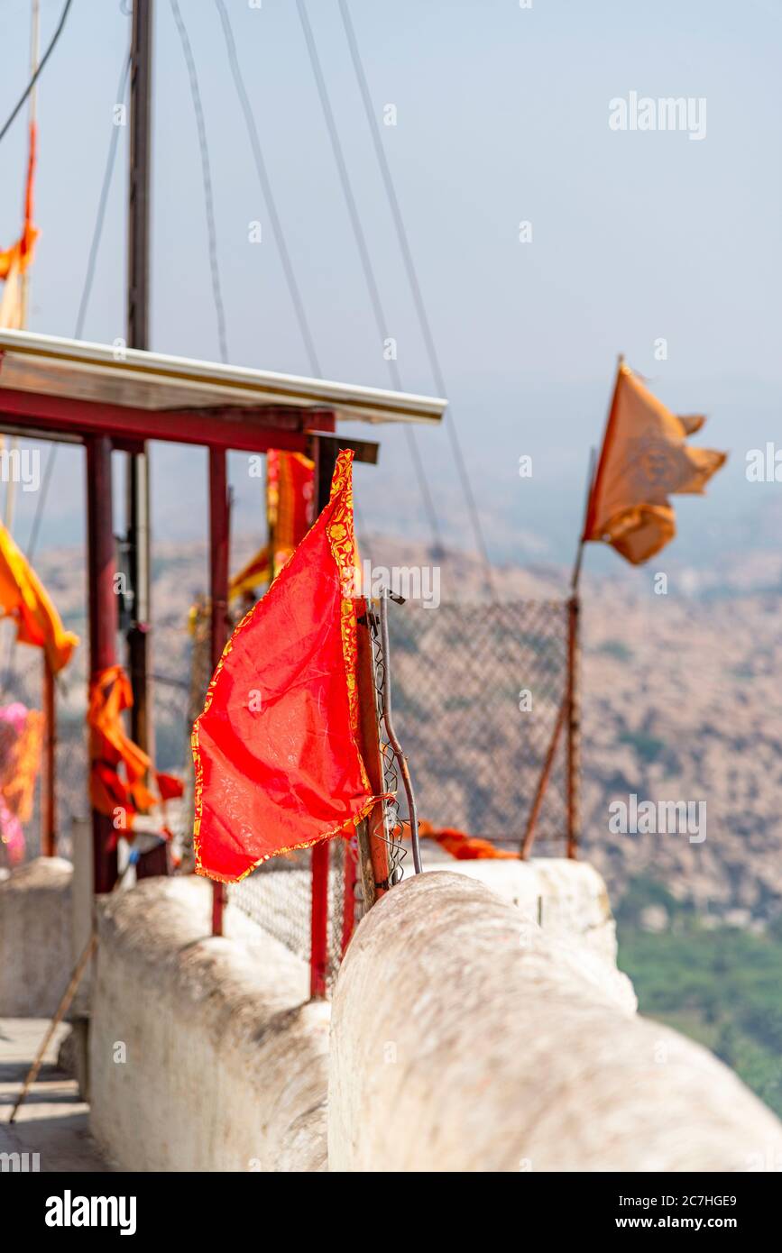 Parapet of the Monkey Temple with orange flags and rocks in the background. Stock Photo