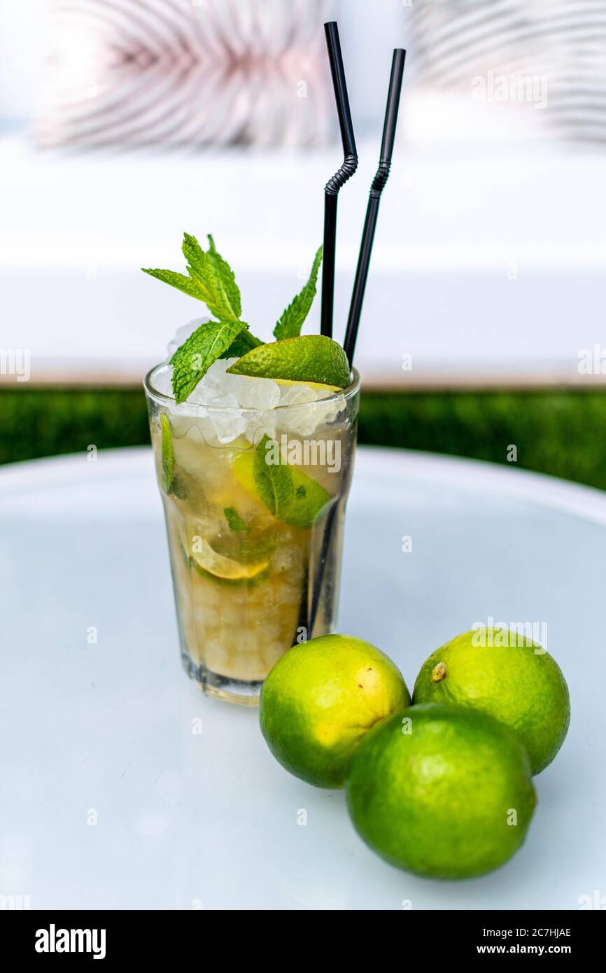 a close up image of a freshly made mojito cocktail on a table with lime garnish Stock Photo