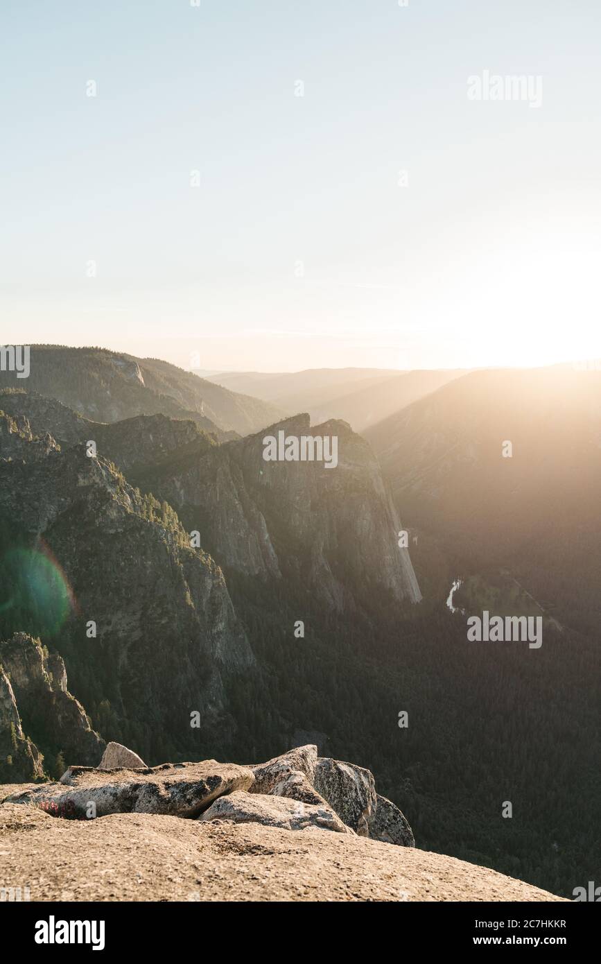 Vertical breathtaking scenery of the sun rising over a rock formation ...