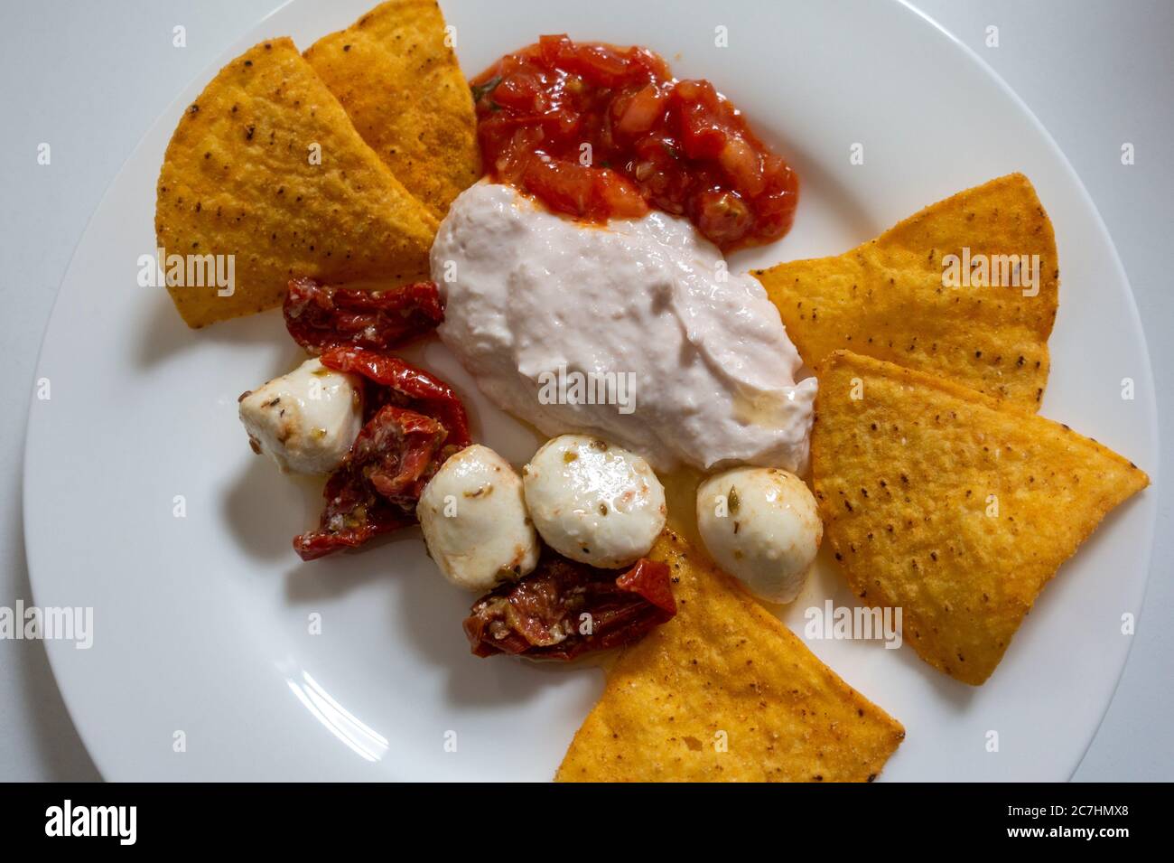 Antipasti of taramasalata, tomato salsa, mozzarella balls, tomatoes, and nachos Stock Photo