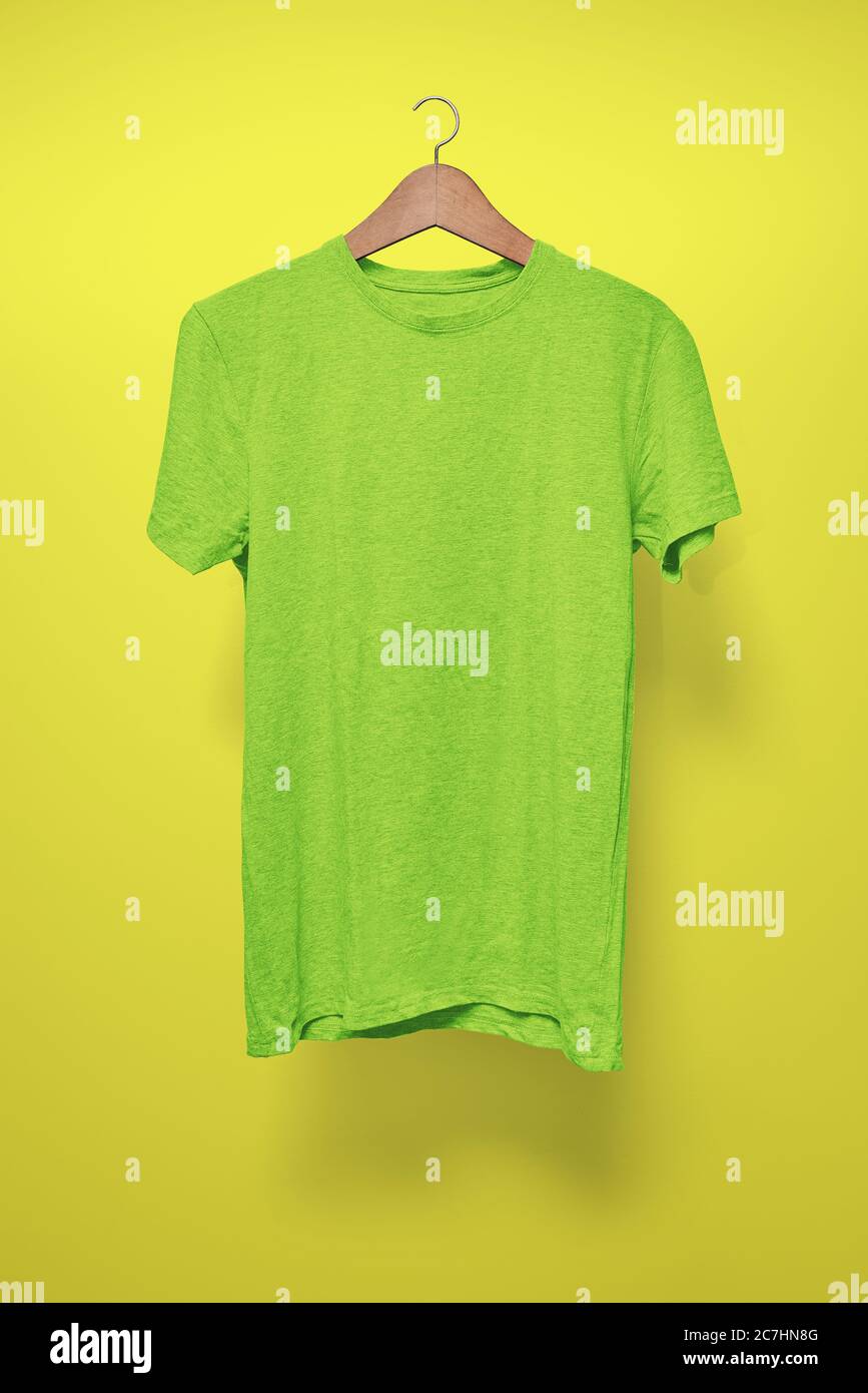 https://c8.alamy.com/comp/2C7HN8G/green-t-shirt-on-a-hanger-against-a-yellow-background-2C7HN8G.jpg