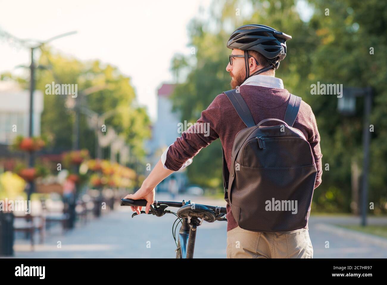 Portrait of a male commuter wearing bike helmet in a town. Safe cycling in city, bicycle