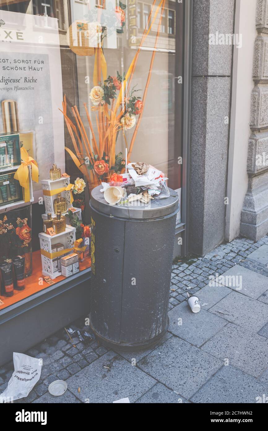 An overflowing trash can in Munich city center. Disadvantages of fast food. Stock Photo