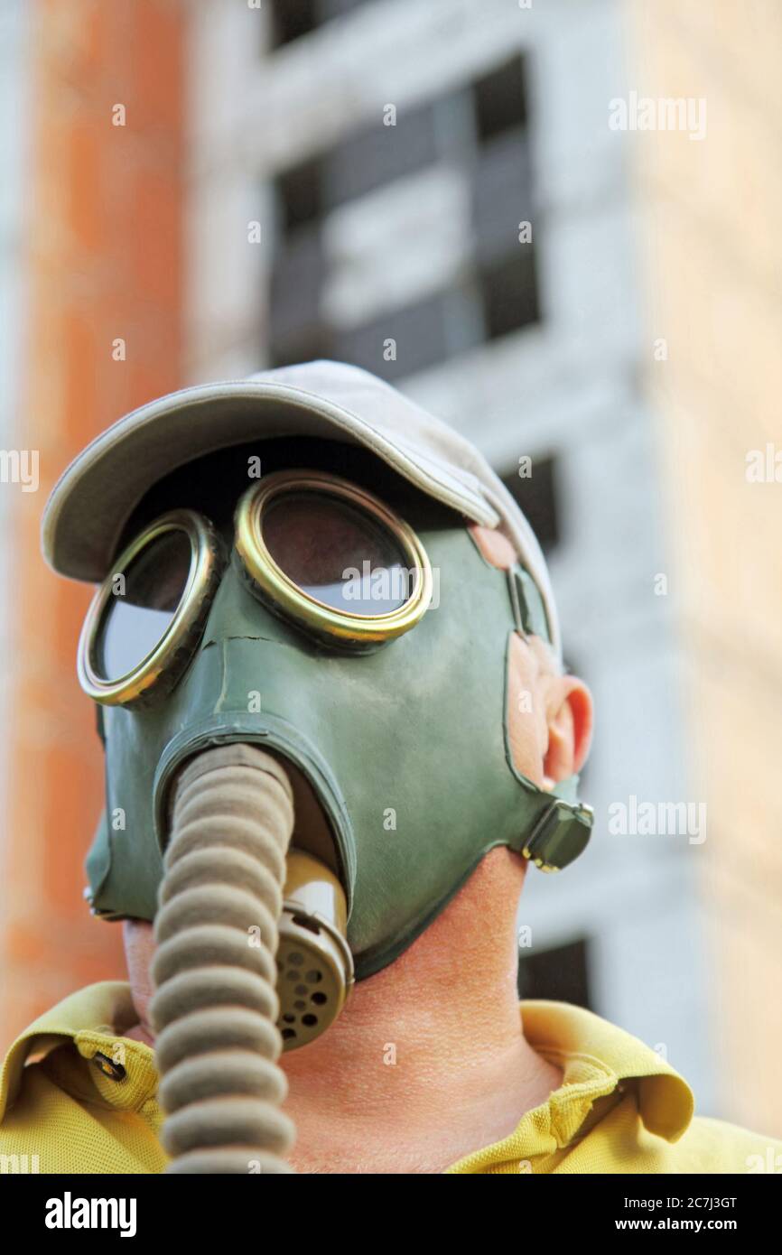 Men in gas mask closeup on destroyed building background. Apocalyptic