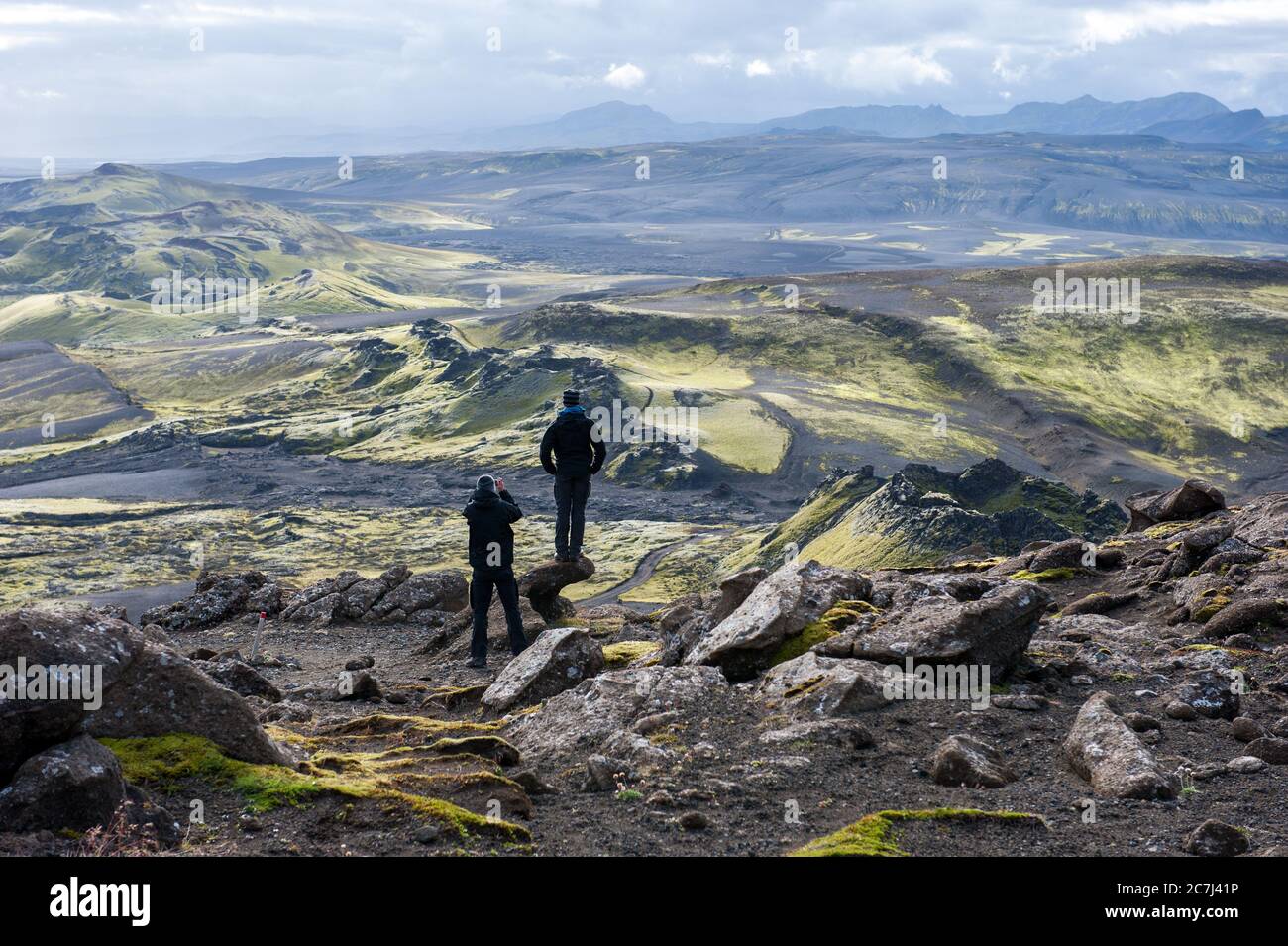 Two hikers looking at volcanic landscape in Lakagigar, Laki craters, Iceland Stock Photo