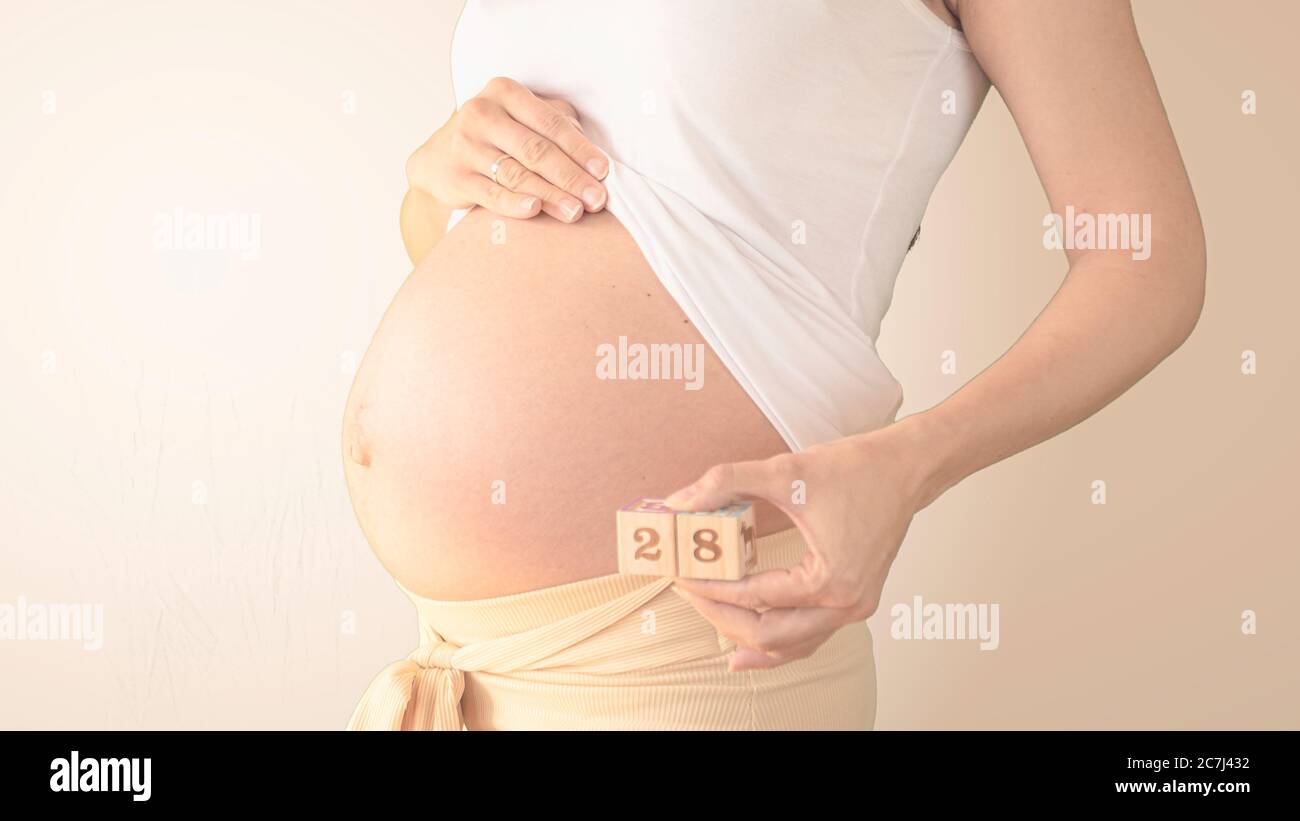 Pregnant Young Woman With Pregnancy Week Number Next To Her Belly Photos Of Belly Growth At 28 Weeks Pregnancy Healthy Pregnancy Diet Stock Photo Alamy