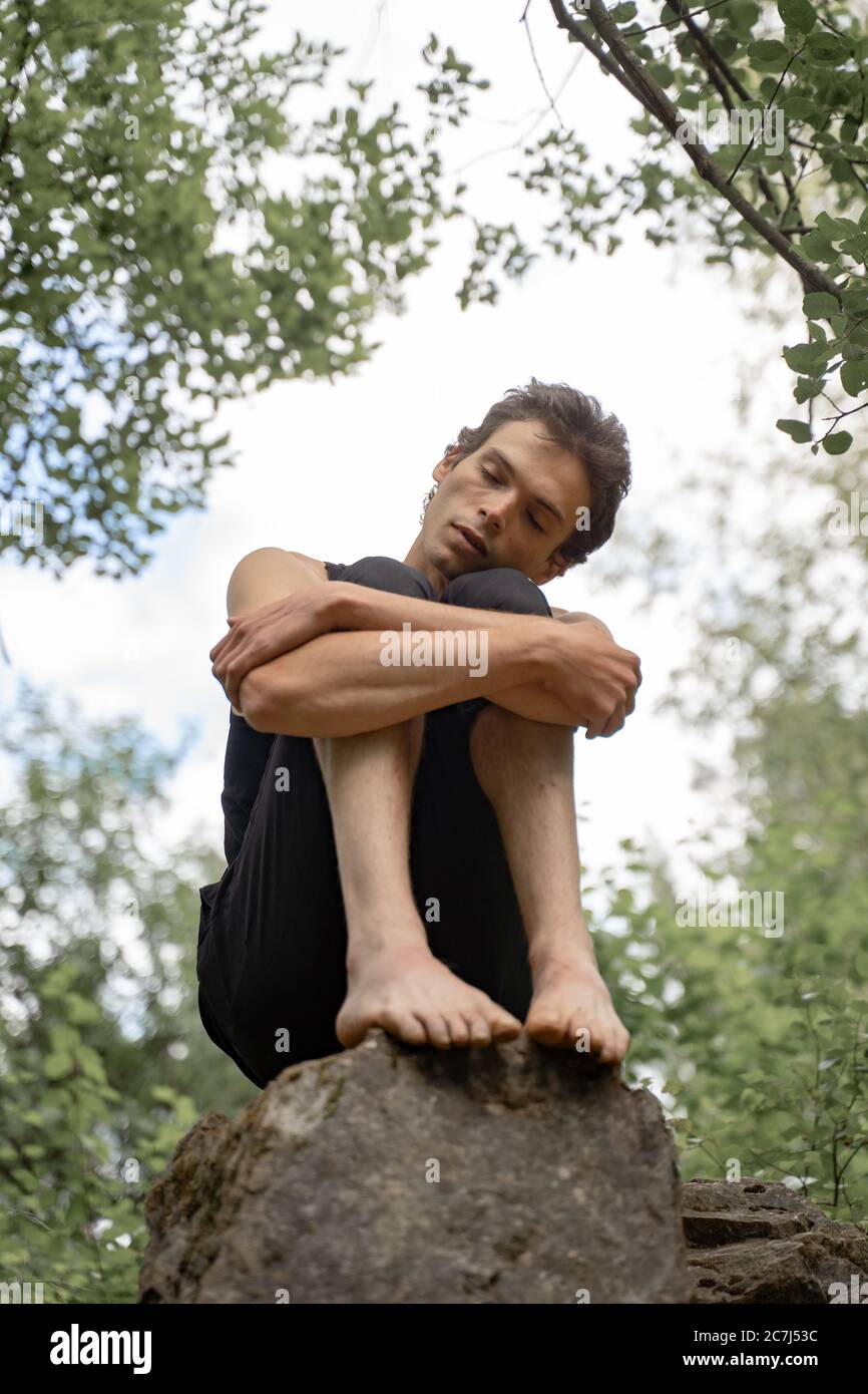 Man sitting hugging knees hi-res stock photography and images - Alamy