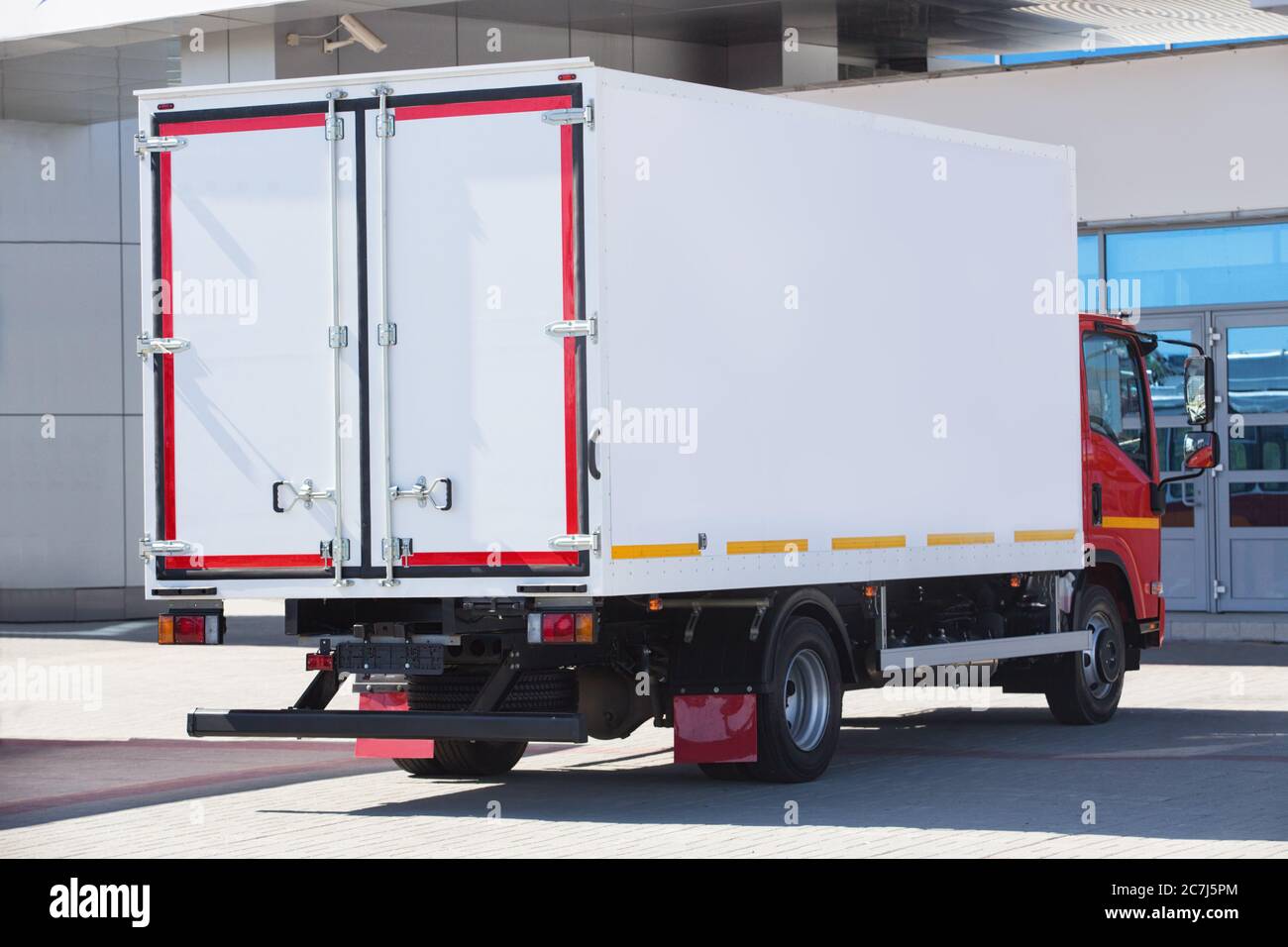 truck with container near building facade Stock Photo
