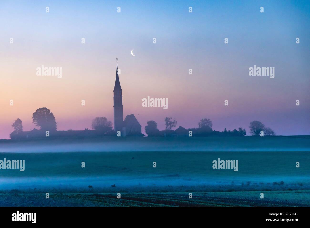 church Mariae Himmelfahrt Kirchreit, late Gothic church at dawn in mist with moon, Germany, Bavaria, Soyen Stock Photo