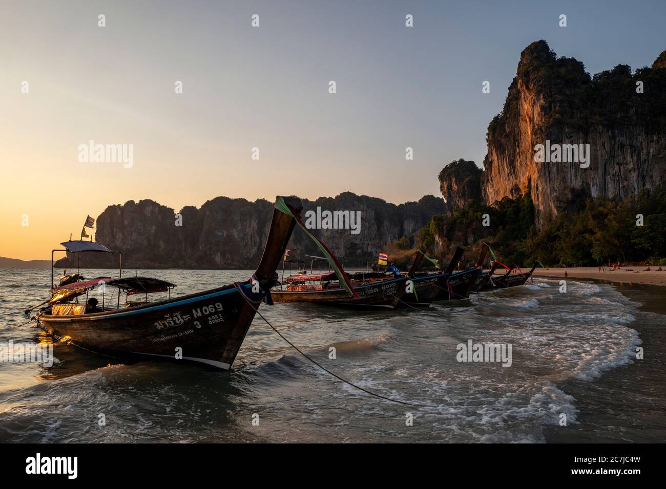 Long tail boats at sunset at Railay beach near Krabi, Thailand Stock Photo