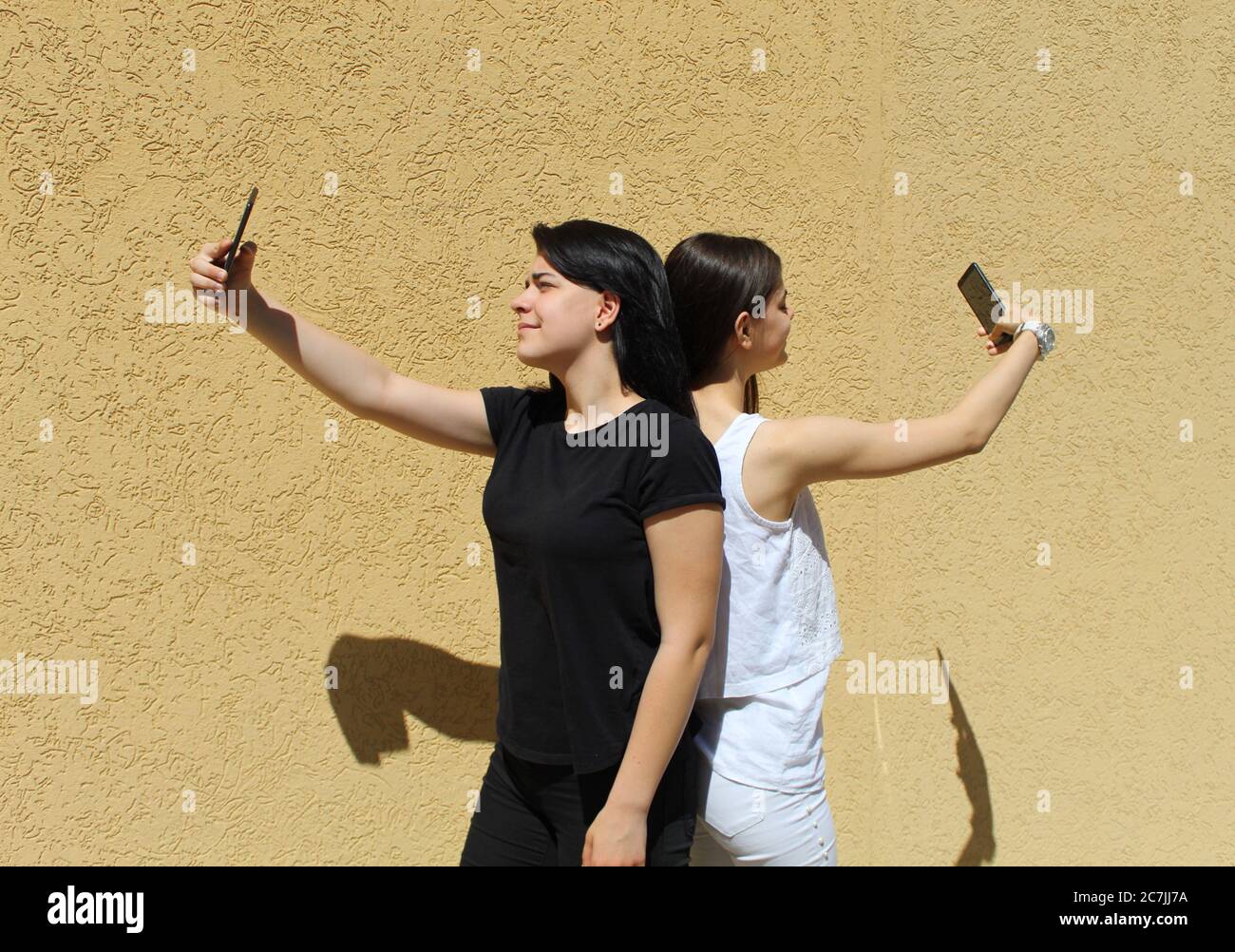 Two girls in black and white clothes take selfies Stock Photo - Alamy