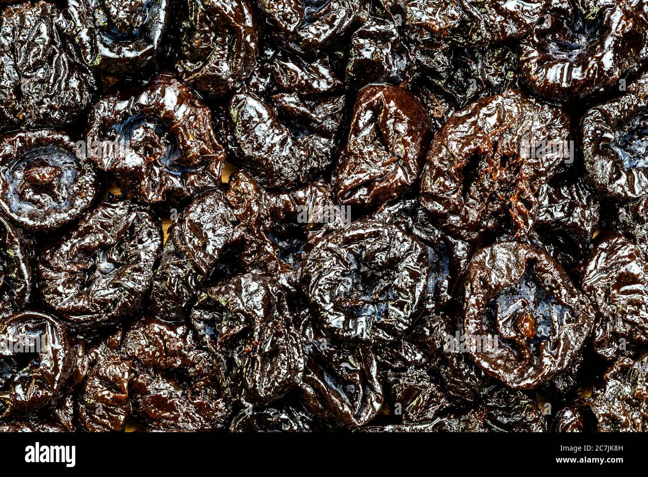 Top view of pitted prunes on wooden board. Prunes are 64 carbohydrates including dietary fiber