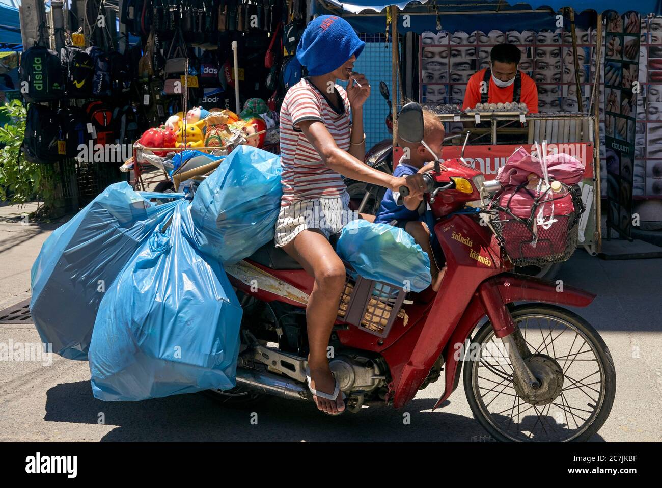 Overloaded motorcycle. Woman riding loaded motorbike with child