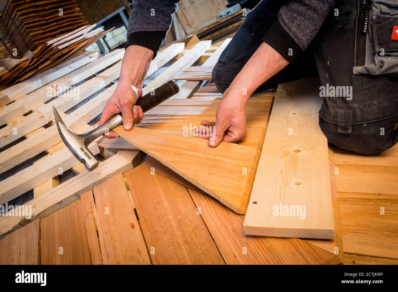 Germany, Bavaria, carpenter fastens wooden shingles Stock Photo