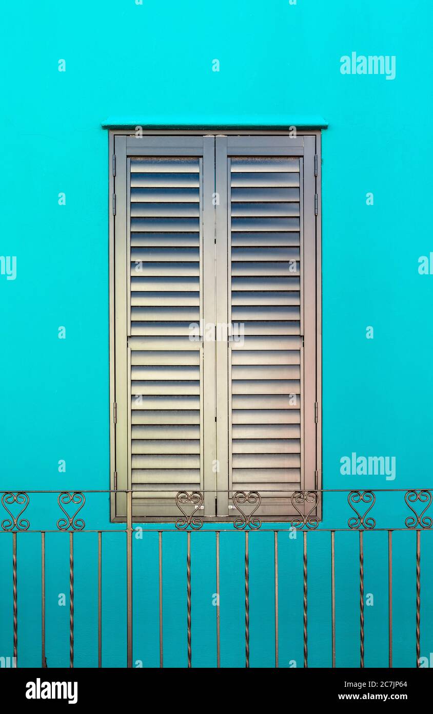 Closed iron window and wrought iron decorations with turquoise facade, Bo Kaap malay quarter, Cape Town, South Africa. Stock Photo