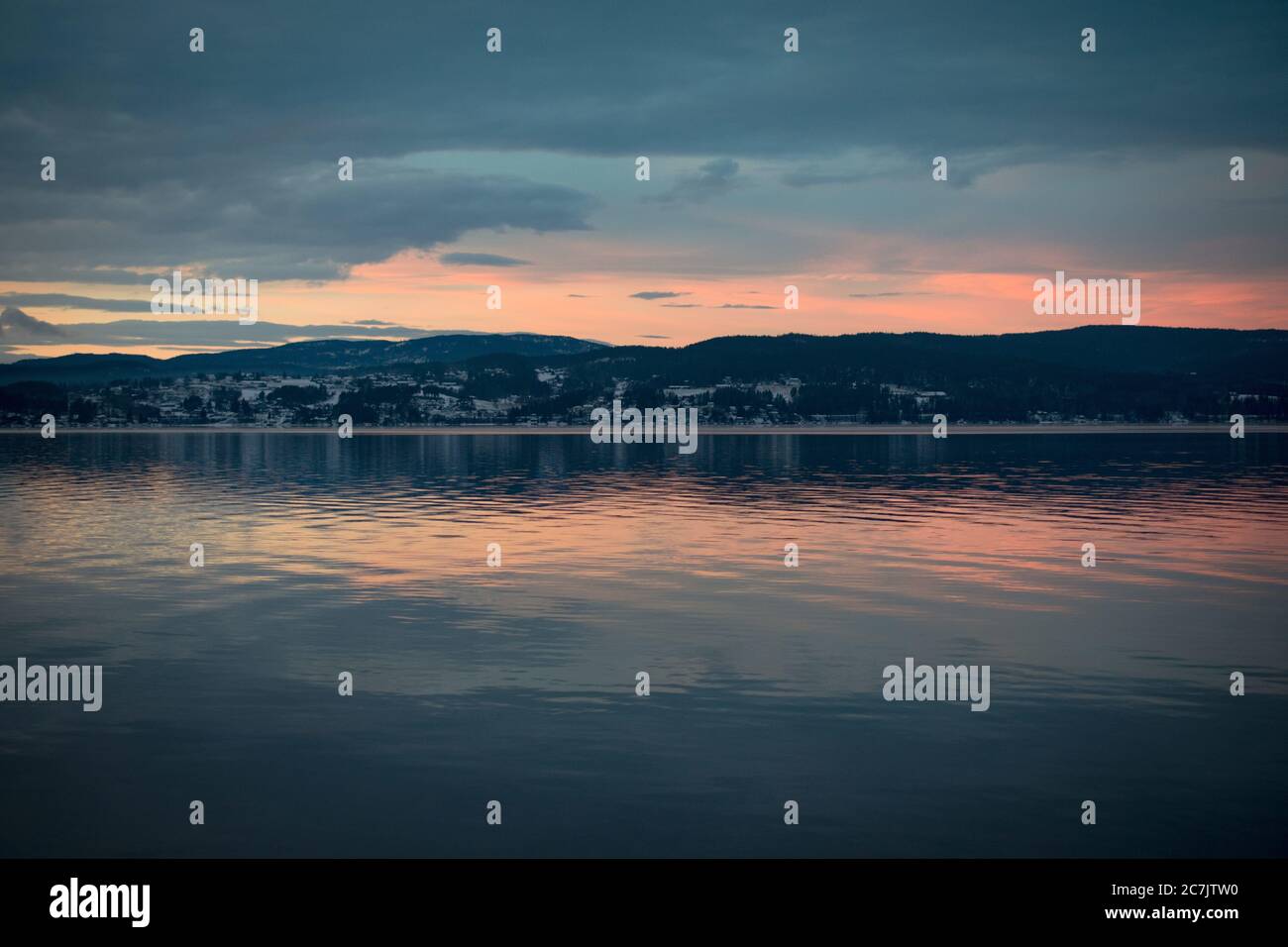 Beautiful scenery of the sunset reflecting on the sea surrounded by ...