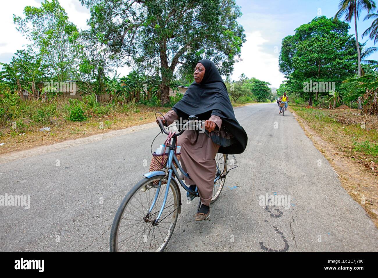 Students returning to their homes bike after finishing school, Zanzibar, Tanzania Stock Photo