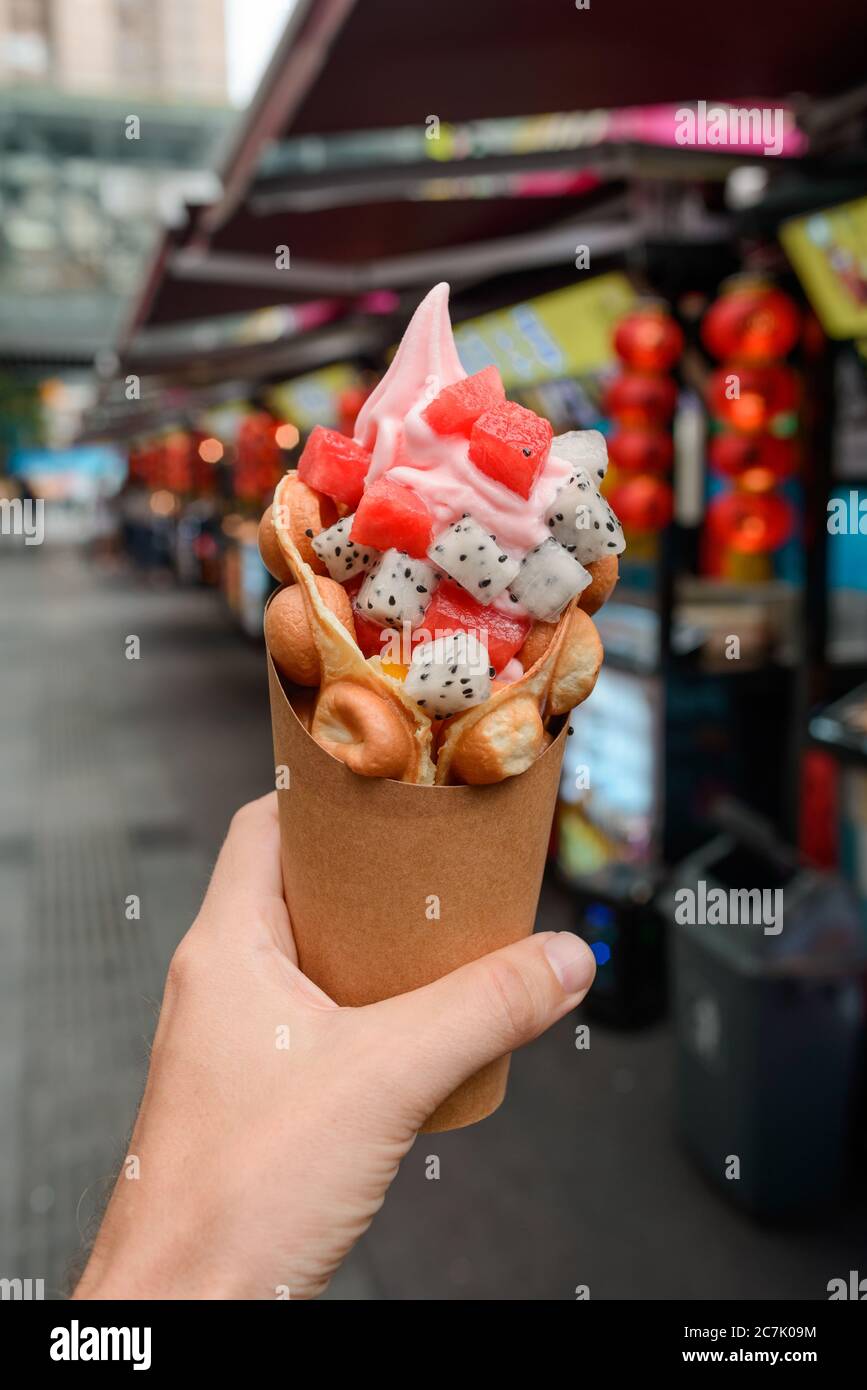 Egg waffle cone with fruits in hand Stock Photo Alamy