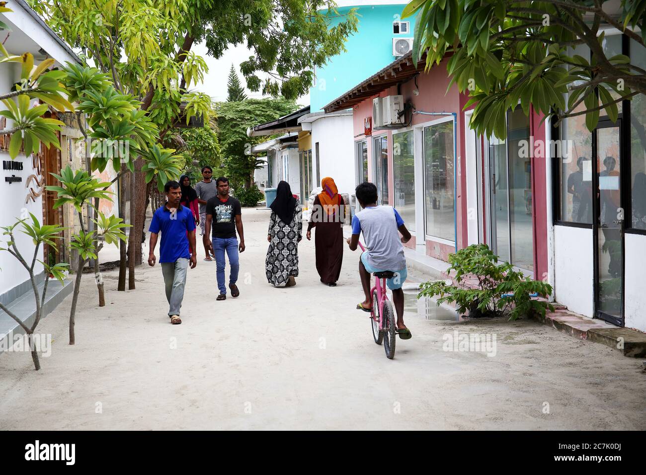 Calle tipica de la isla de Guraidhoo con gente caminando, Isla Gulhi Maldivas Stock Photo