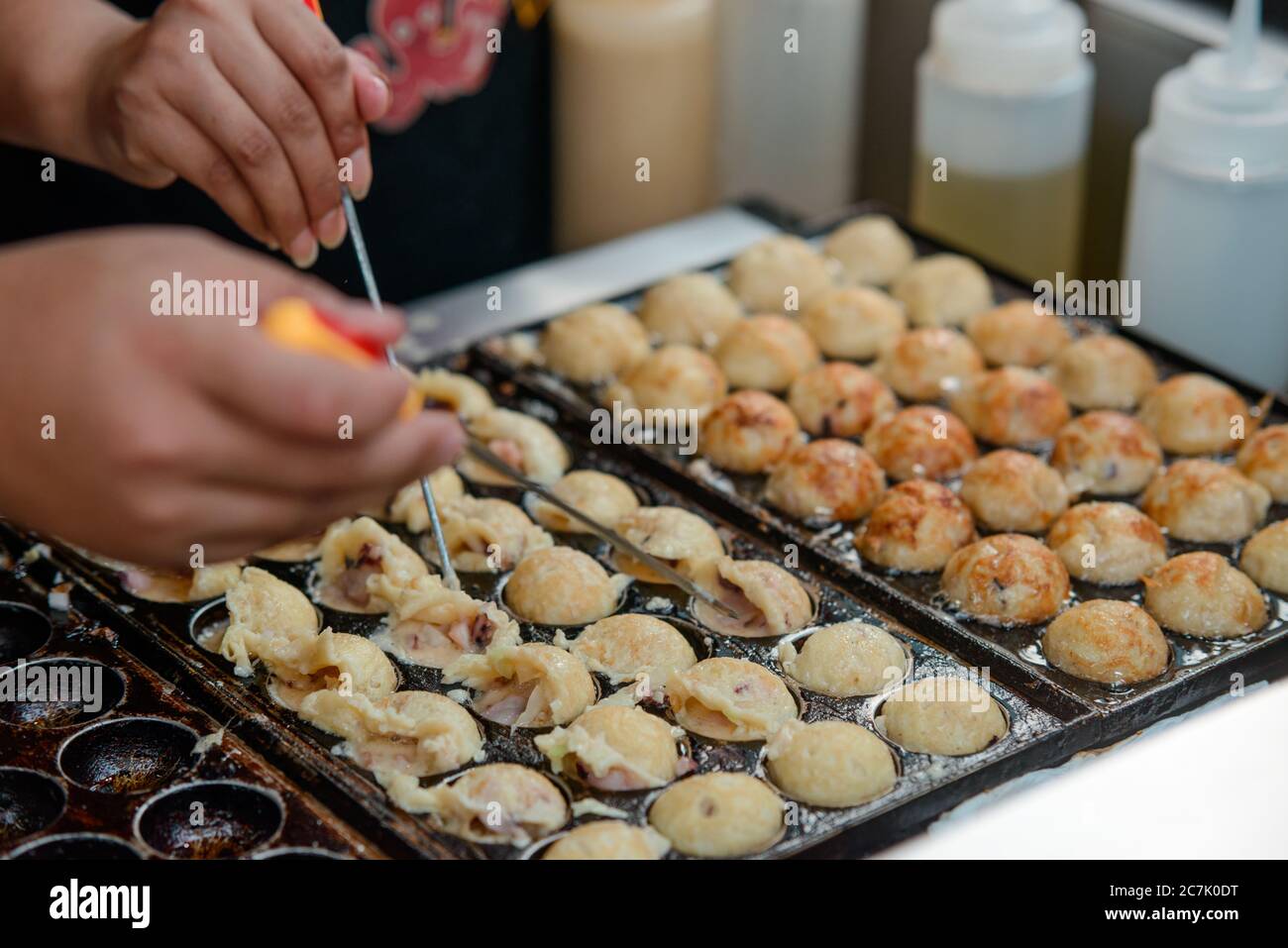Cooking Takoyaki balls with octopus. Japanese snack for sale Stock
