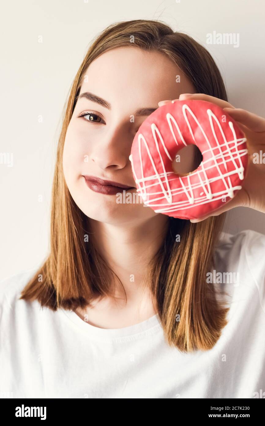 Beautiful girl holding donut and having fun on white background. Funny joyful woman with sweets, dessert. Diet, dieting concept. Junk food, Slimming, Stock Photo