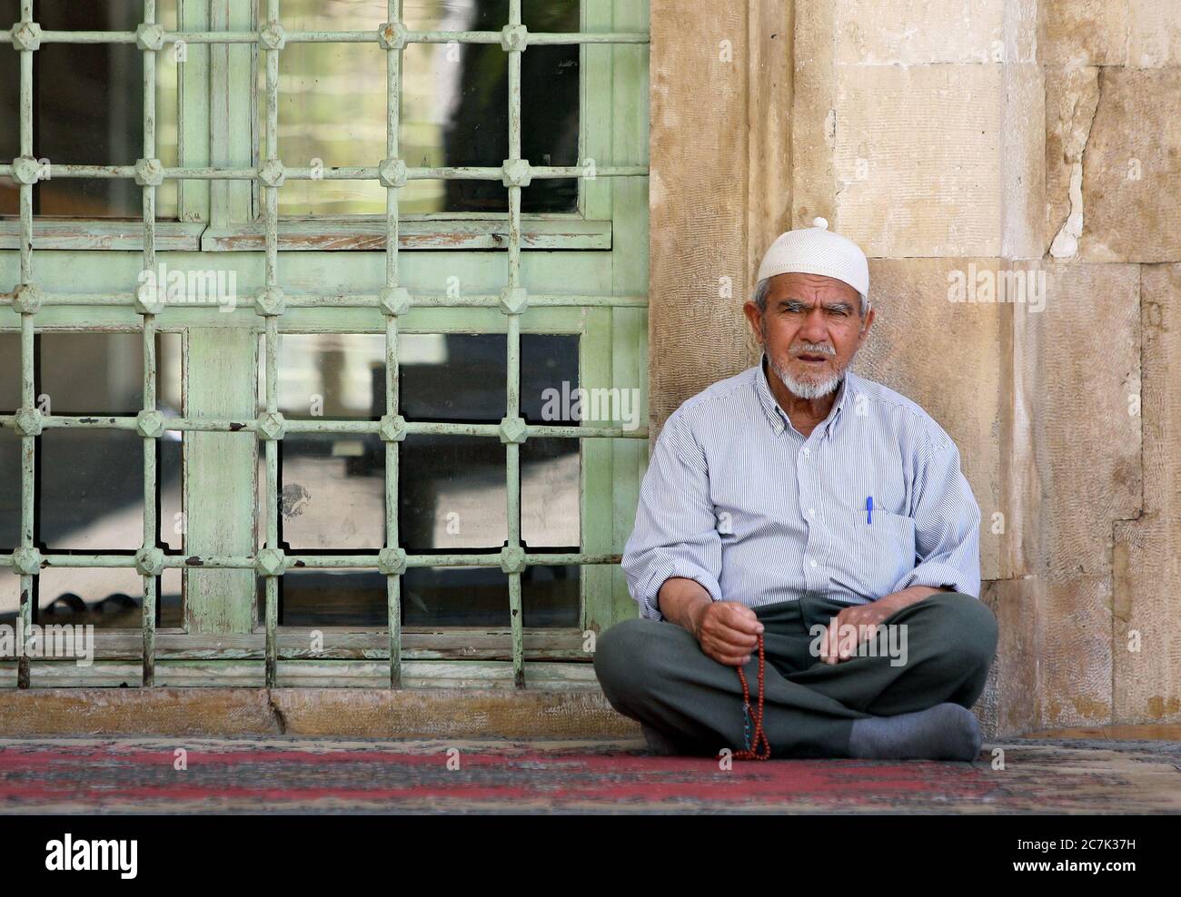 A Turkish man sits outside the Ketenci Omer Pasha Mosque in the town of ...