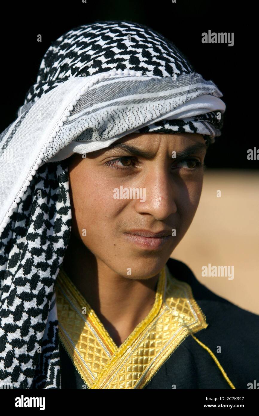 Portrait of a teenage boy of Arabian decent wearing a keffiyeh on his head in the ancient town of Harran in Turkey. Stock Photo