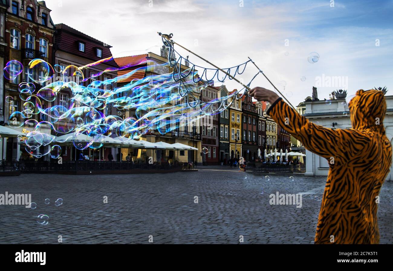 Person wearing a tiger costume making bubbles on the street in Poznan,  Polonia Stock Photo - Alamy