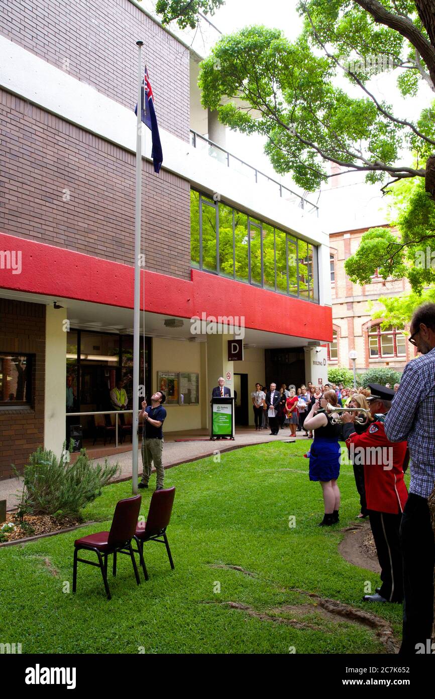 The Australian flag is raised at the end of the minute’s silence at the traditional Remembrance Day service at Ultimo TAFE in Sydney. Stock Photo