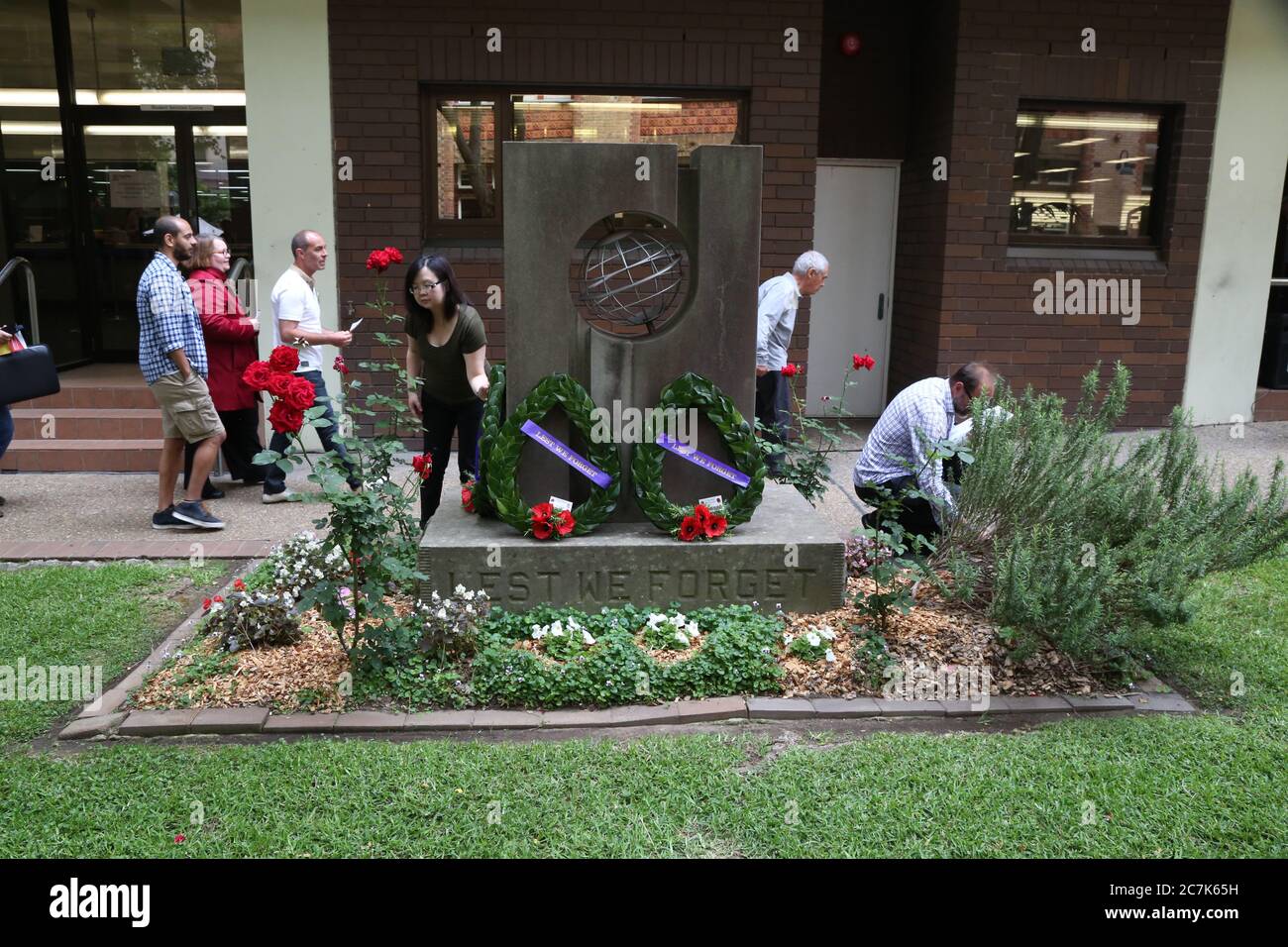 Wreaths are laid and people take photos at the memorial at the end of the traditional Remembrance Day service at Ultimo TAFE in Sydney. Stock Photo