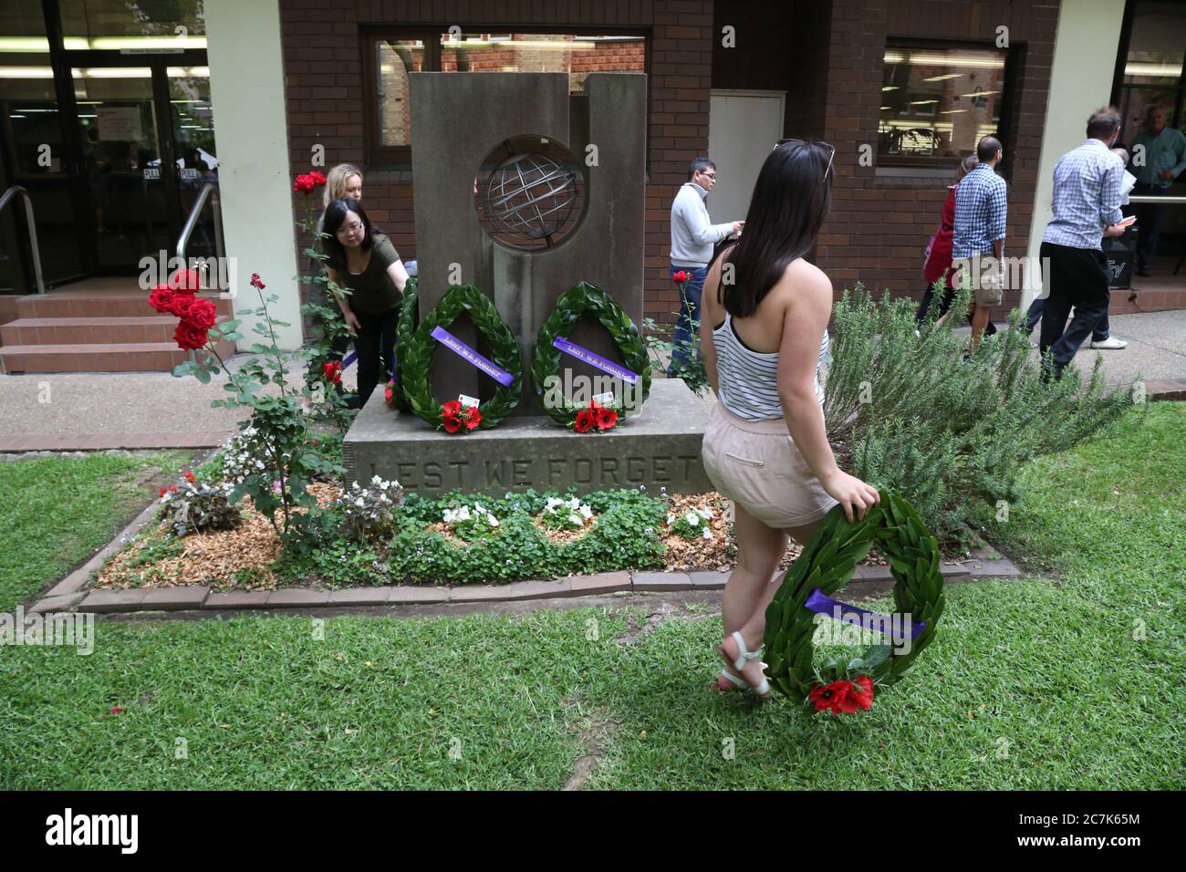 Wreaths are laid and people take photos at the memorial at the end of the traditional Remembrance Day service at Ultimo TAFE in Sydney. Stock Photo